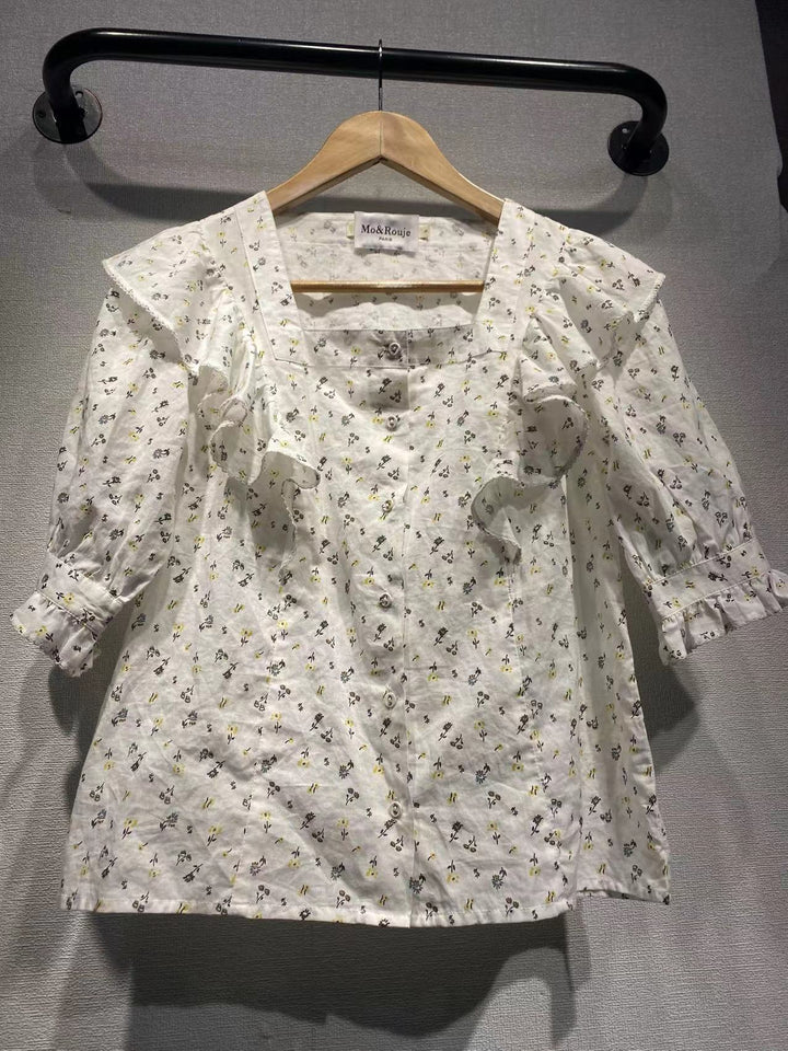 Damebluse med elegante flæsedetaljer og blomstret mønster Stilla