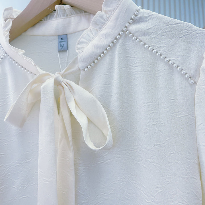 Damebluse med flæsedetaljer og elegant sløjfe Stilla