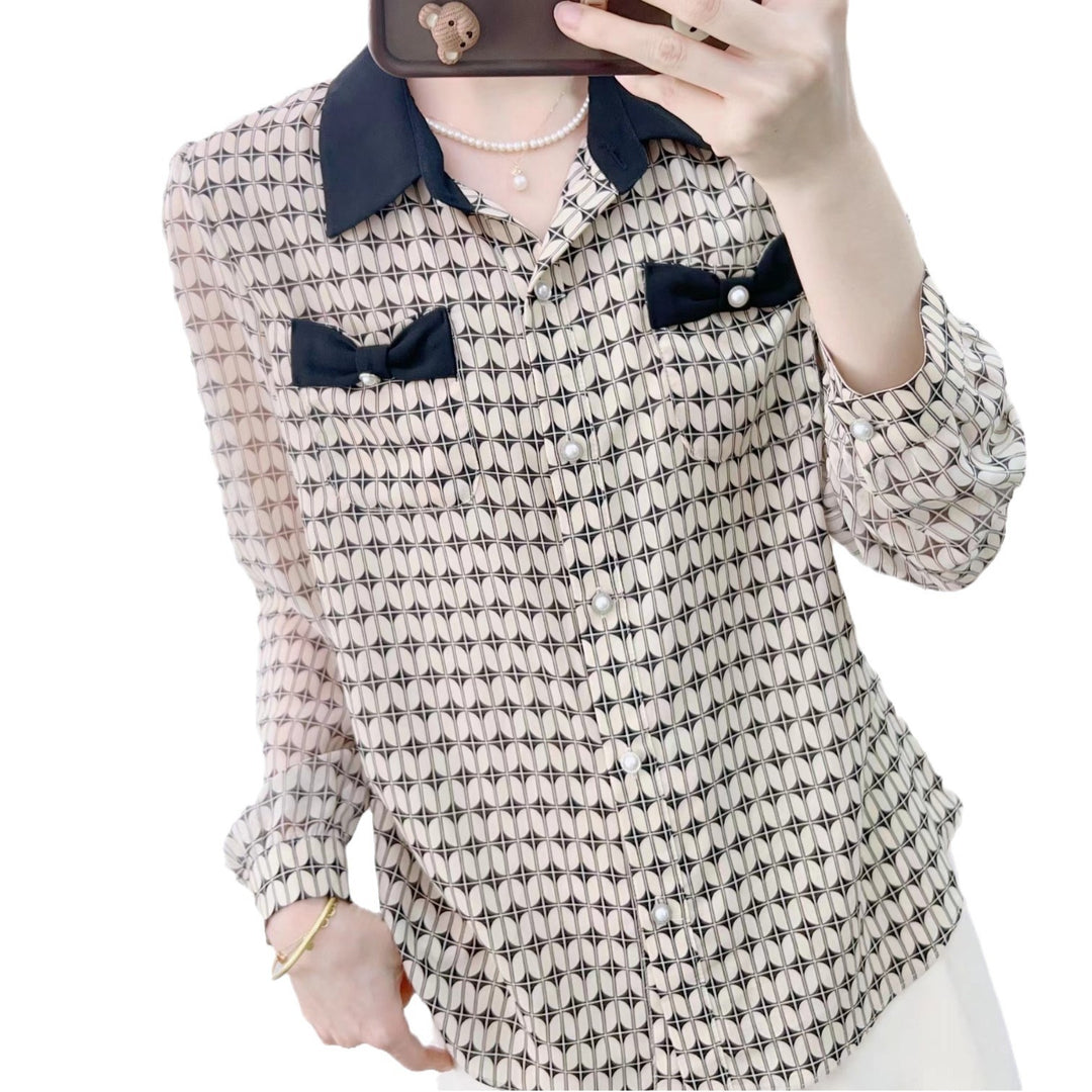 Damebluse med modeprint og elegante sløjfeapplikationer Stilla