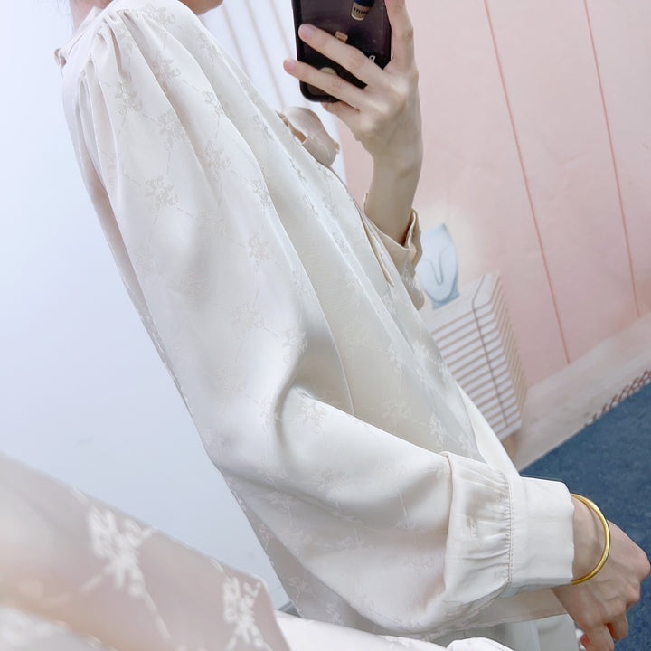 Damebluse med elegant sløjfe og floralt mønster Stilla