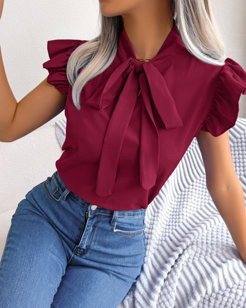 Damebluse med flæsedetaljer og elegant sløjfe Stilla