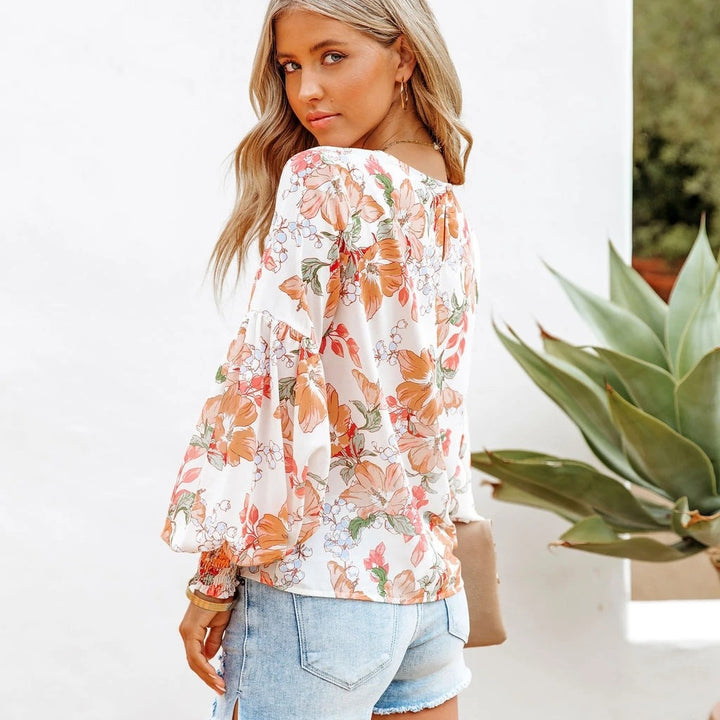 Damebluse med voluminøse ærmer og blomstret design Stilla