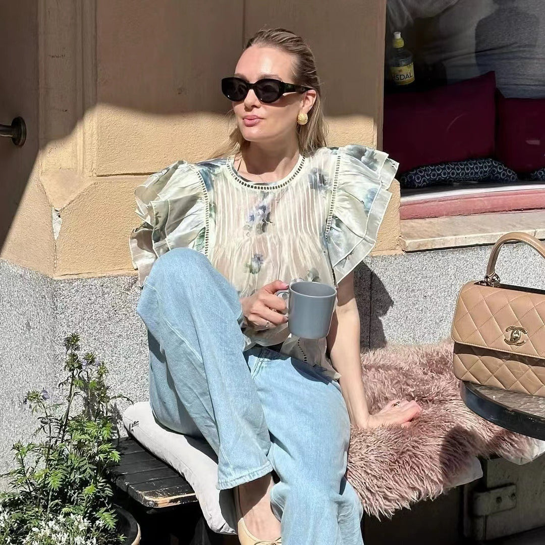 Damebluse med overdådige flæsedetaljer og sarte blomsterdesign Stilla