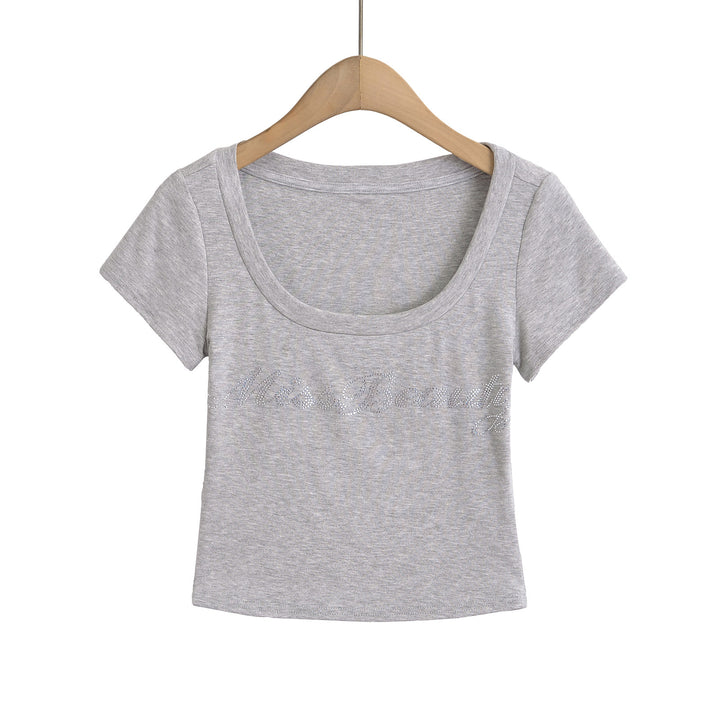 Dame crop-top med elegant rund hals og glitrende skrift Stilla