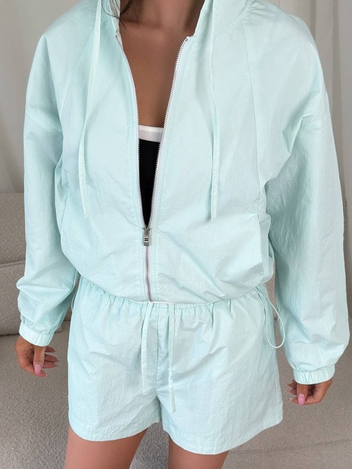 Kvinders sporty sæt med kortærmet bluse og hættejakke samt elastisk talje.
