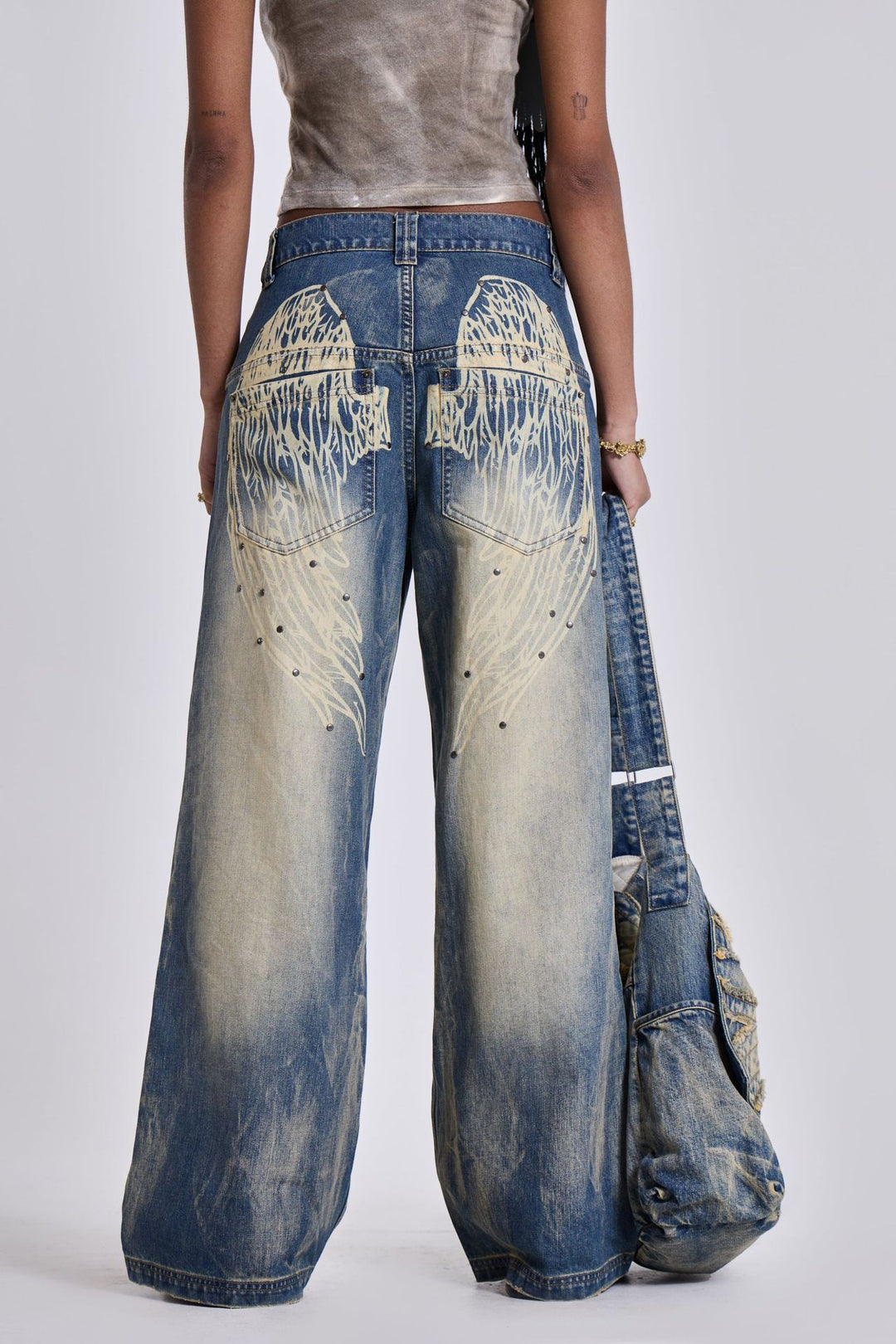 Dame Løst skårede jeans med iøjnefaldende englevinge-design og moderigtig brugt-look Stilla